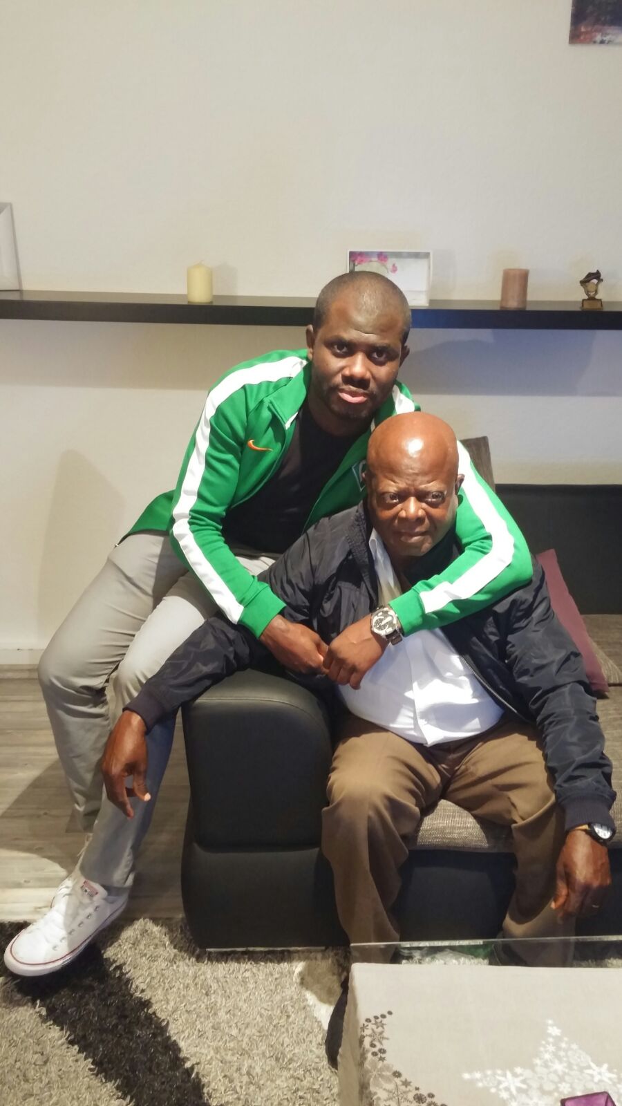 MBOGBE MBOGBE assis, son fils autour de ses épaules