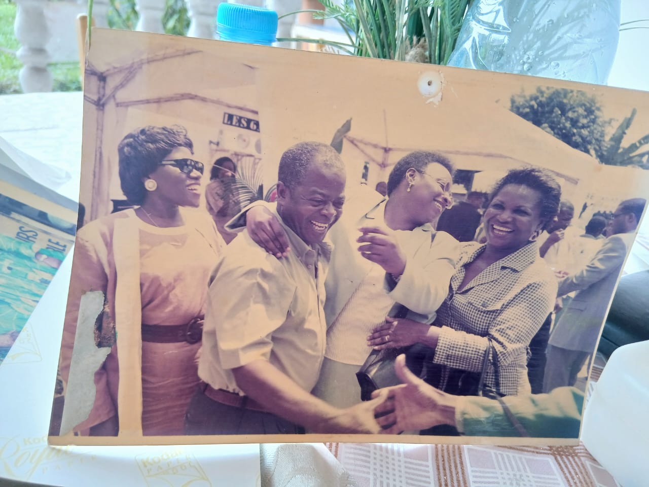 MBOGBE MBOGBE riant entouré d'amis lors d'une fête